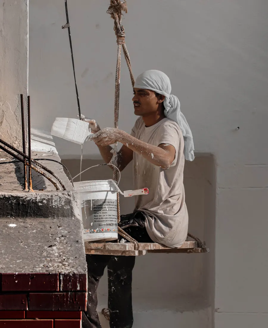 Pintor de Nani trabajando en altura, sentado en la silleta, preparando la pintura